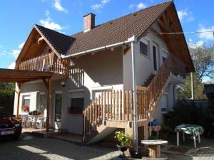 Casa blanca pequeña con escalera de madera en Apartment in Balatonmariafürdo 19297, en Balatonmáriafürdő