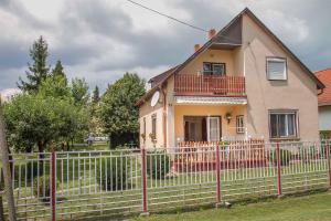 uma casa com uma cerca em frente em Holiday home in Balatonkeresztur 19524 em Balatonkeresztúr