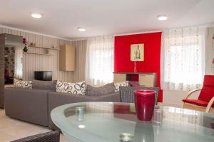 a living room with a couch and a red wall at Holiday home Balatonkeresztur 13 in Balatonkeresztúr