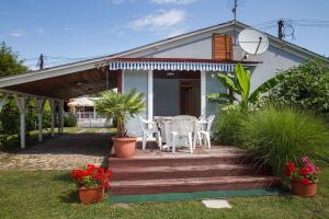 uma casa com um alpendre em madeira com cadeiras e uma mesa em Holiday home in Balatonmariafürdo 19534 em Balatonmáriafürdő