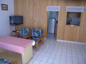 een keuken met een tafel en twee stoelen en een televisie bij Apartment Gyenesdias 3 in Gyenesdiás