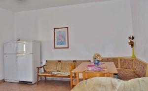 a kitchen with a table and a white refrigerator at Apartment in Lopar/Insel Rab 17739 in Lopar