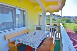 a table and chairs on the balcony of a house at Apartment in Lopar/Insel Rab 17739 in Lopar