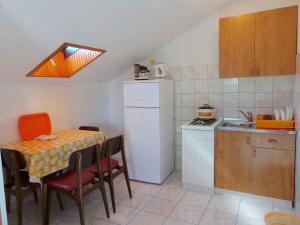 eine kleine Küche mit einem Tisch und einem weißen Kühlschrank in der Unterkunft Apartment in Valbandon/Istrien 11261 in Valbandon