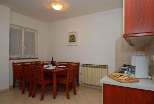 a kitchen with a table and chairs in a kitchen at Apartment Rabac 12 in Rabac