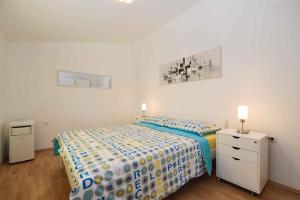 a bedroom with a bed with a blue and yellow comforter at Holiday home Medulin 21 in Medulin