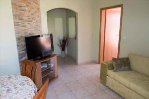 a living room with a couch and a flat screen tv at Apartment Banjol 23 in Rab