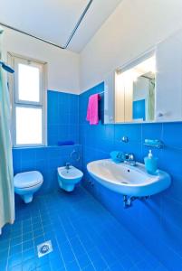 ビビオーネにあるApartments in Bibione 25584の青いバスルーム(洗面台、トイレ付)