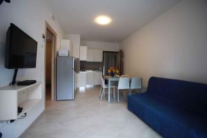 sala de estar con sofá azul y cocina en Apartment in Rosolina Mare 15, en Rosolina Mare