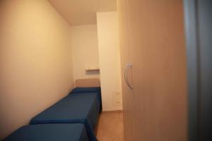 Habitación pequeña con cama azul y armario. en Apartment in Rosolina Mare 15, en Rosolina Mare