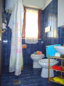 ビビオーネにあるApartments in Bibione 25807の青いタイル張りのバスルーム(トイレ、窓付)