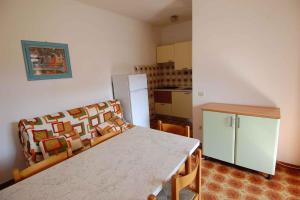 ロゾリーナ・マーレにあるApartments in Rosolina Mare 24851のキッチン(白いテーブル、冷蔵庫付)