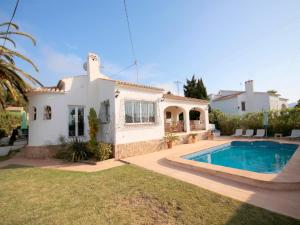 a villa with a swimming pool in front of a house at Holiday Home Anna in Jávea