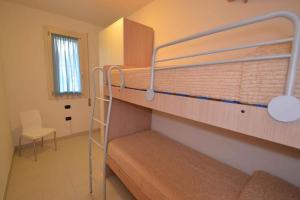 ロザピネタにあるTwo-Bedroom Apartment Rosolina Mare near Sea 18の二段ベッド2台と椅子が備わる客室です。