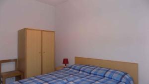 Apartment in Eraclea Mare 25654 في ايراكليا ماري: غرفة نوم بسرير وخزانة خشبية