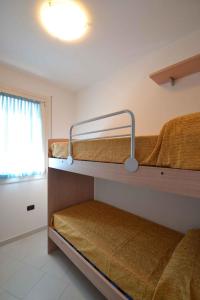 ロザピネタにあるTwo-Bedroom Apartment Rosolina Mare near Sea 9の二段ベッド2台と窓が備わる客室です。