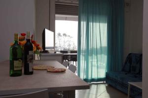 Sala de estar con mesa y 2 botellas de vino en Two-Bedroom Apartment Rosolina Mare near Sea 3, en Rosolina Mare