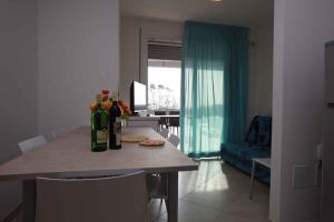 ロゾリーナ・マーレにあるTwo-Bedroom Apartment Rosolina Mare near Sea 3のキッチン(ワインボトル付きのテーブル付)