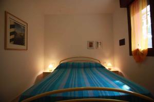 ロザピネタにあるApartment Rosolina Mare 21のベッドルーム1室(青いベッド1台、ランプ2つ付)