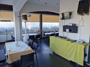 un ristorante con tavoli, sedie e una televisione di Holiday home Modica 1 a Modica