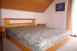バラトンマーリアフュルドゥーにあるHoliday home in Balatonmariafürdo 19511のベッドルーム1室(木製ヘッドボード付きのベッド1台付)
