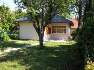 biały garaż z drzewem na podwórku w obiekcie Holiday home in Balatonfenyves 18357 w mieście Balatonfenyves