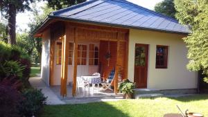 mały domek ze stołem i krzesłami na dziedzińcu w obiekcie Holiday home in Balatonfenyves 18357 w mieście Balatonfenyves