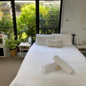 a white bed with two pillows on top of it at Bali In Berrara in Berrara