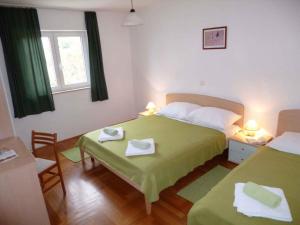 - une chambre avec 2 lits et une table avec des serviettes dans l'établissement Apartment Barbat 8, à Barbat na Rabu