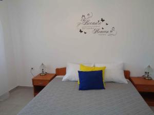 a bedroom with a bed with two night stands and a sign at Two-Bedroom Apartment Lopar near Sea 2 in Lopar