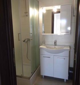 a bathroom with a sink and a shower with a mirror at Two-Bedroom Apartment Lopar near Sea 2 in Lopar