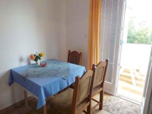 un tavolo con sedie, un tavolo blu e una finestra di Apartment Zadar, Zadar County 8 a Smirić