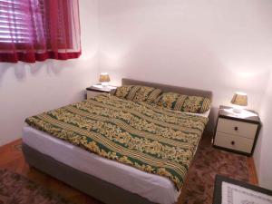 una piccola camera con un letto e due comodini di Apartment Zadar, Zadar County 8 a Smirić