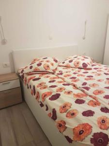 a bed with a floral comforter and two pillows at Apartment Lopar 12 in Lopar