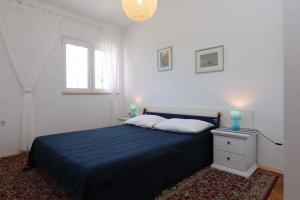 a bedroom with a blue bed and a window at Apartment in Silo/Insel Krk 13416 in Šilo