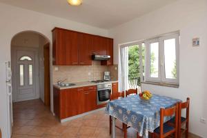a kitchen with a table with a table cloth on it at Apartment in Silo/Insel Krk 13433 in Šilo