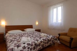 a bedroom with a bed and a chair and a window at Apartment in Silo/Insel Krk 13433 in Šilo