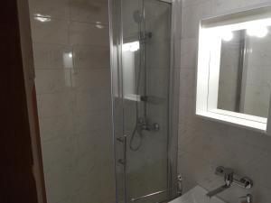 La salle de bains est pourvue d'une douche, d'un lavabo et d'un miroir. dans l'établissement Apartment Senj 1, à Senj