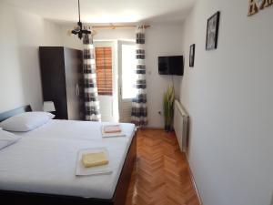 - une petite chambre avec un lit et une télévision dans l'établissement Apartment Senj 1, à Senj