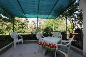 stół i krzesła na patio z zielonym baldachimem w obiekcie Apartment Silo 36 w mieście Šilo