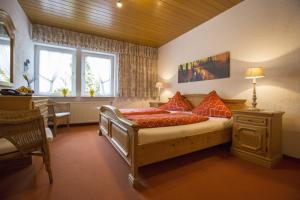 a bedroom with a bed with red pillows at Hotel-Pension-Waldblick Garni in Gittersdorf