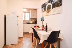 uma cozinha com uma mesa com cadeiras e um frigorífico branco em Apartment Pula, Brijuni, Istria 2 em Veruda
