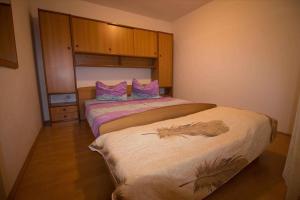 a bedroom with two beds with pink and purple pillows at Apartment Kampor 1 in Kampor