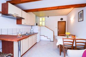 eine Küche mit weißen Schränken und einem Tisch und Stühlen in der Unterkunft Apartment in Pula - Istrien 11023 in Pula