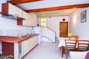 a kitchen with white cabinets and a table and chairs at Apartment in Pula/Istrien 11023 in Veruda