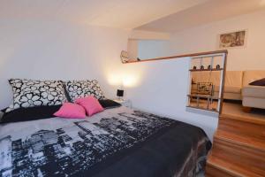 ein Schlafzimmer mit einem Bett mit rosa Kissen und einem Sofa in der Unterkunft Apartment in Pula - Istrien 11023 in Pula
