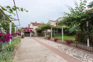 a house with a walkway in a yard with flowers at Apartment Fazana 28 in Fažana