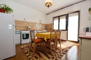 a kitchen with a table and chairs and a refrigerator at Apartment Medulin 6 in Medulin