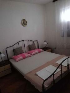 a bedroom with a large bed with pink pillows at Apartment in Petrcane/Zadar Riviera 7866 in Petrcane