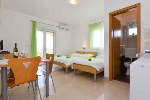 um quarto com 2 camas, uma mesa e uma cozinha em Apartment Ljubac 5 em Ljubac